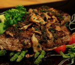ta dish of seared steak on a bed of green vegetables